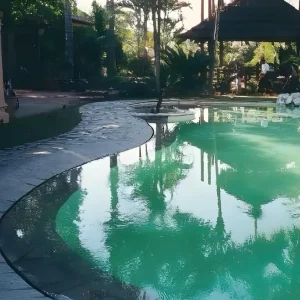 Piscine miroir dont les bords disparaissent dans l'eau, créant un effet de continuité avec la terrasse paysagée