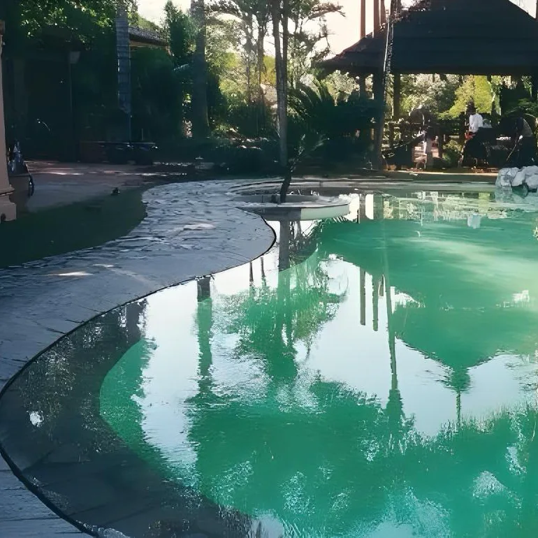 Piscine miroir dont les bords disparaissent dans l'eau, créant un effet de continuité avec la terrasse paysagée