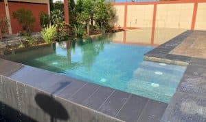 Vue réelle de la piscine à débordement trois côtés construite au Togo avec banc de massage intégré
