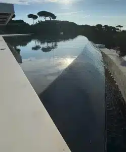 Goulotte de débordement utilisée comme bac tampon dans une piscine à débordement