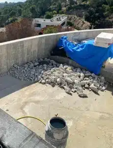Vue partielle de la construction d'une piscine à débordement montrant l'importance de l'arase du débordement