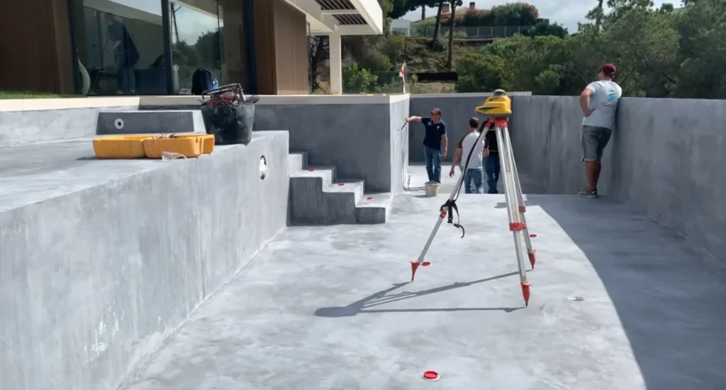 construction piscine à débordement – vérification des niveaux au laser sur chantier